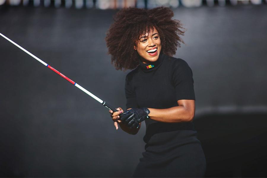 Person holding a golf club casually, smiling