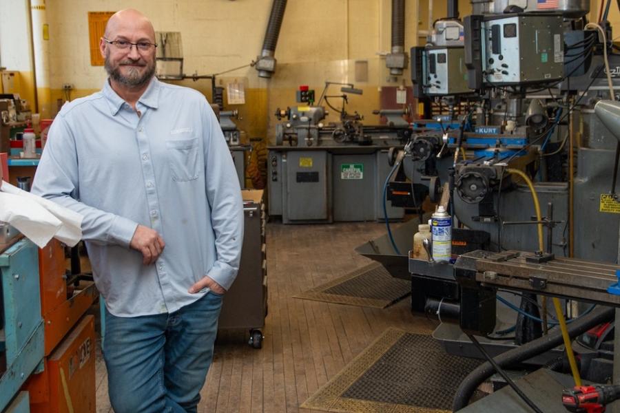 Person posing in front of a room full of machines