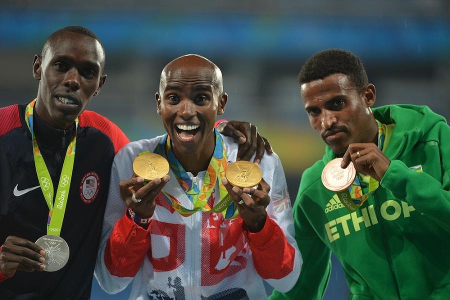 Three people holding up medals they've just won