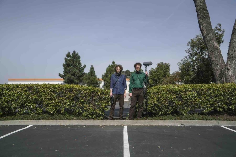 two people with microphone standing outside