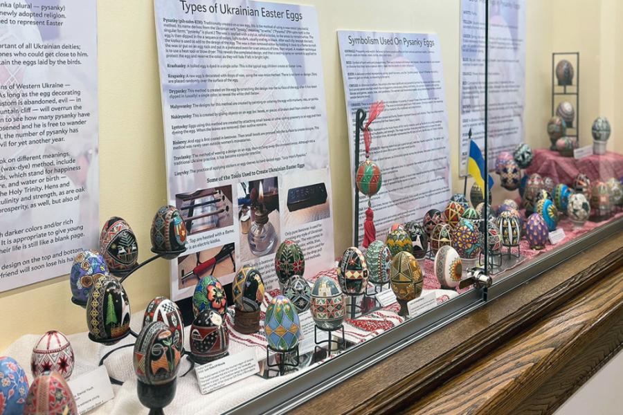 A display case filled with colorful Easter eggs and interpretive posters