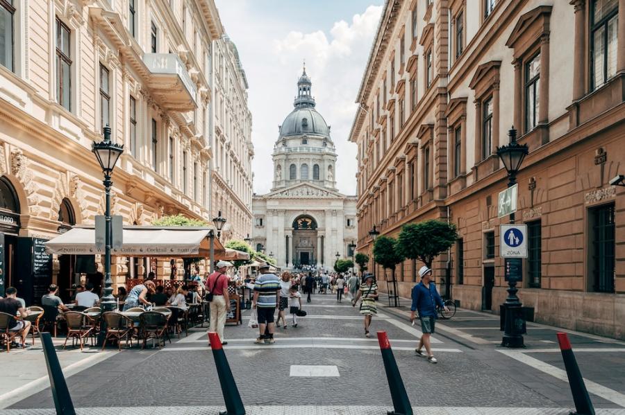 City street with pedestrians and a busy sidewalk cafe