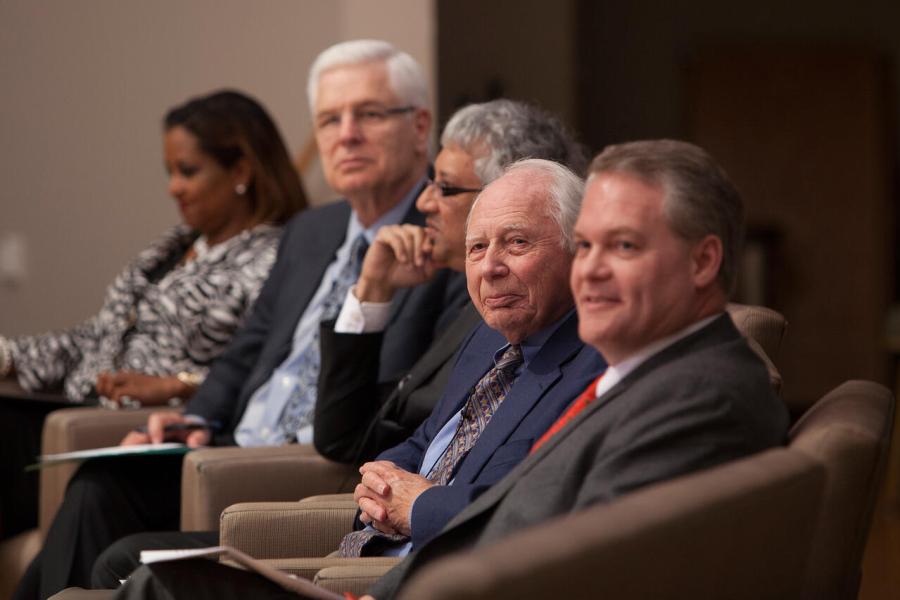 Five people sitting in chairs on a stage for an academic panel