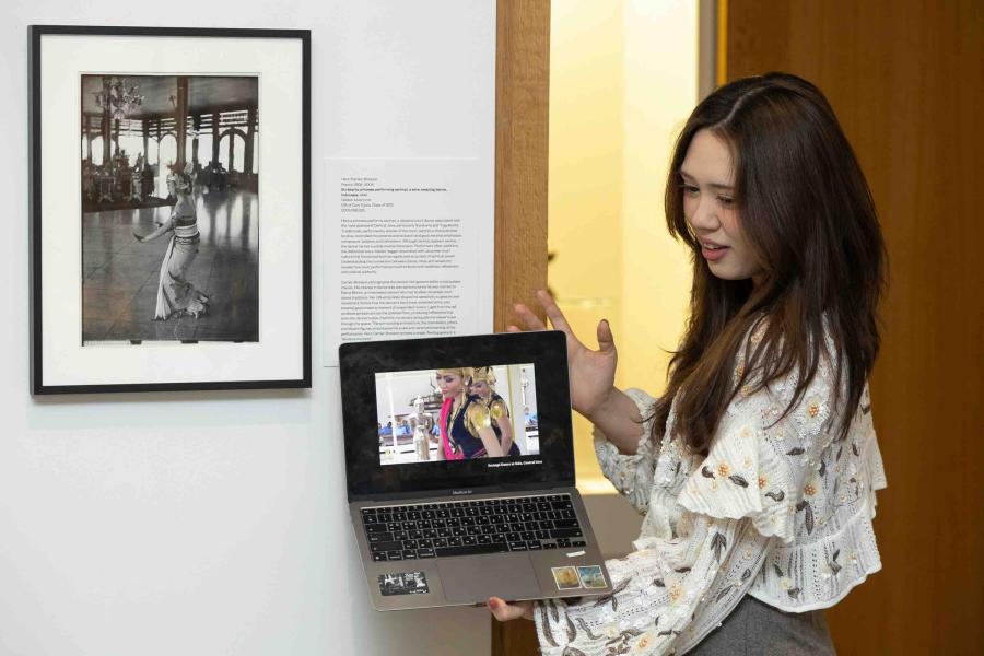 person holding computer near artwork