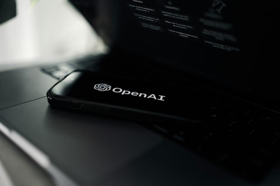 Dark phone screen shows a white OpenAI logo