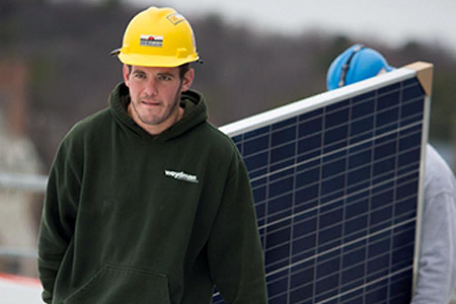  Workers walking with a solar panel