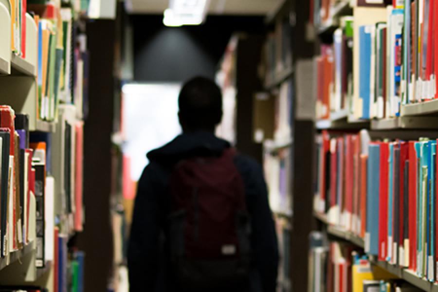  Figure shadowed by shelves of library books