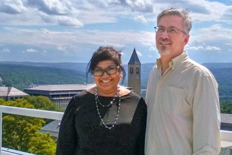 Two people, with Cornell campus in background