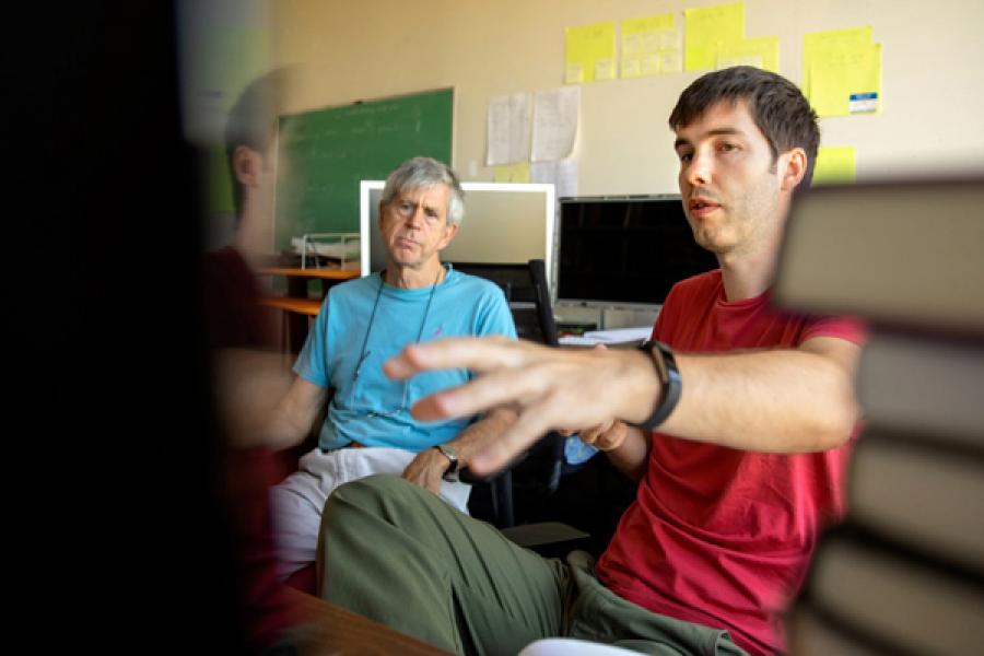 Thomas Davidson, right, a doctoral student in the field of sociology, at work in the Social Dynamics Laboratory run by Michael Macy, back, the Goldwin Smith Professor of Arts and Sciences in sociology.