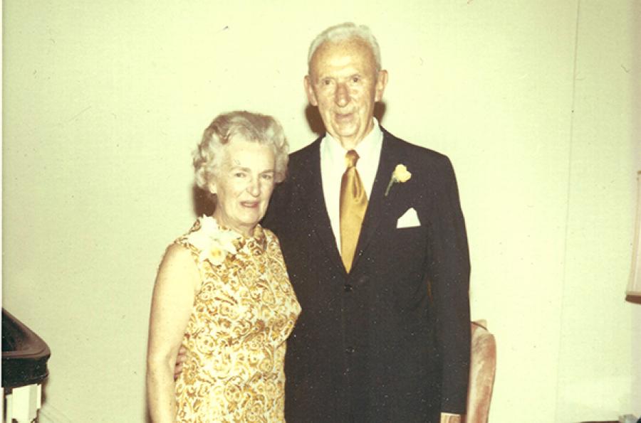 Two people with white hair pose in fancy clothes