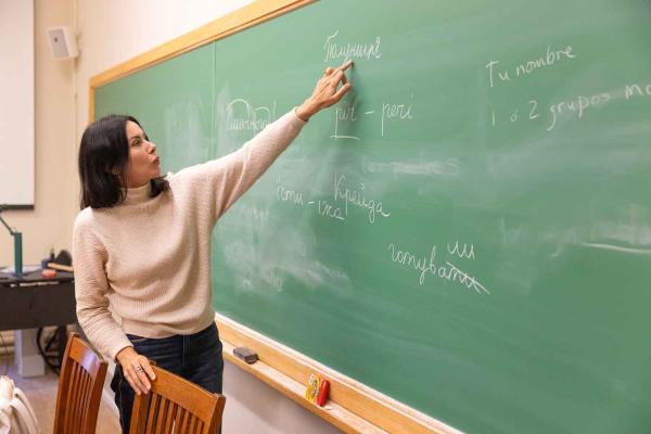 woman showing Ukrainian words on chalkboard