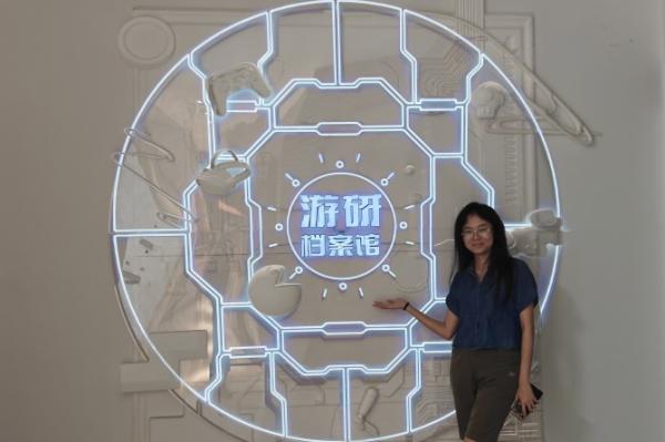 Person standing in front of a large glowing neon circle outline with Chinese characters in the center