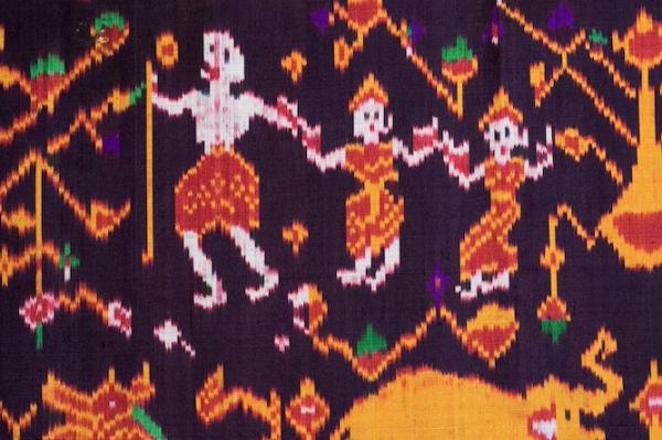 Detail of a woven cloth showing figures dressed in red and yellow