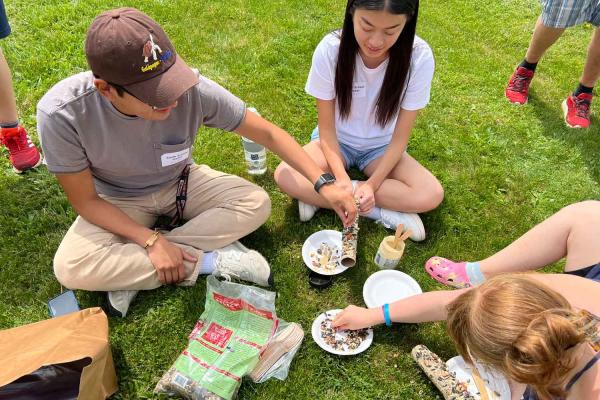 people pouring bird seed into bowls