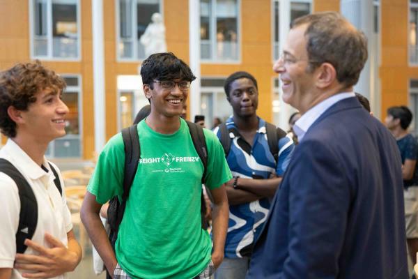 man talking to two students