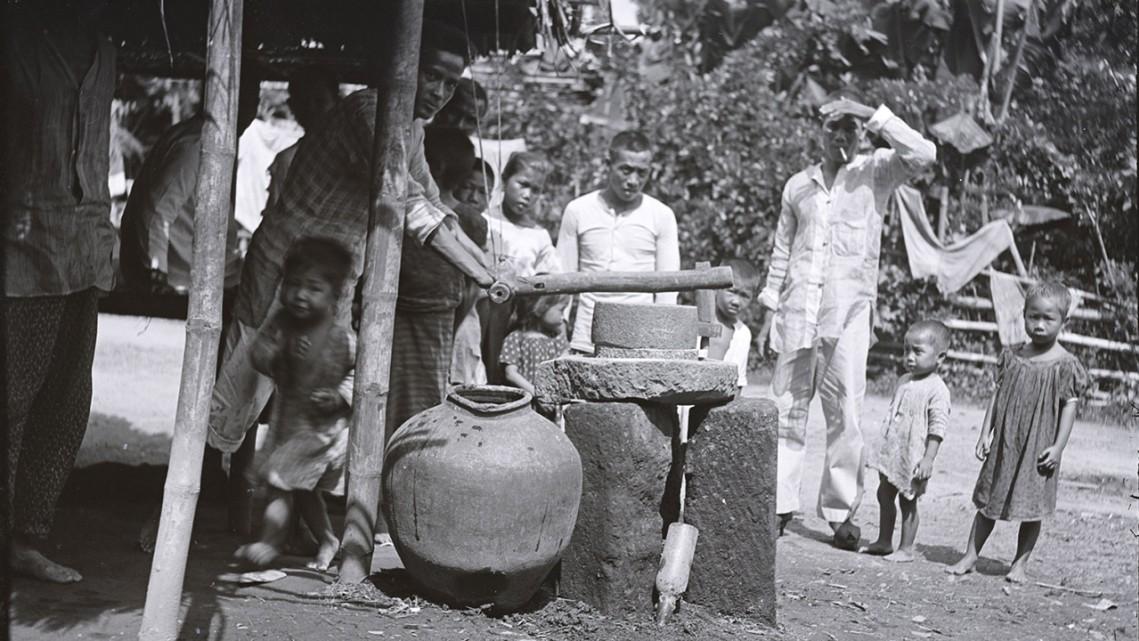 Several people stand near a well