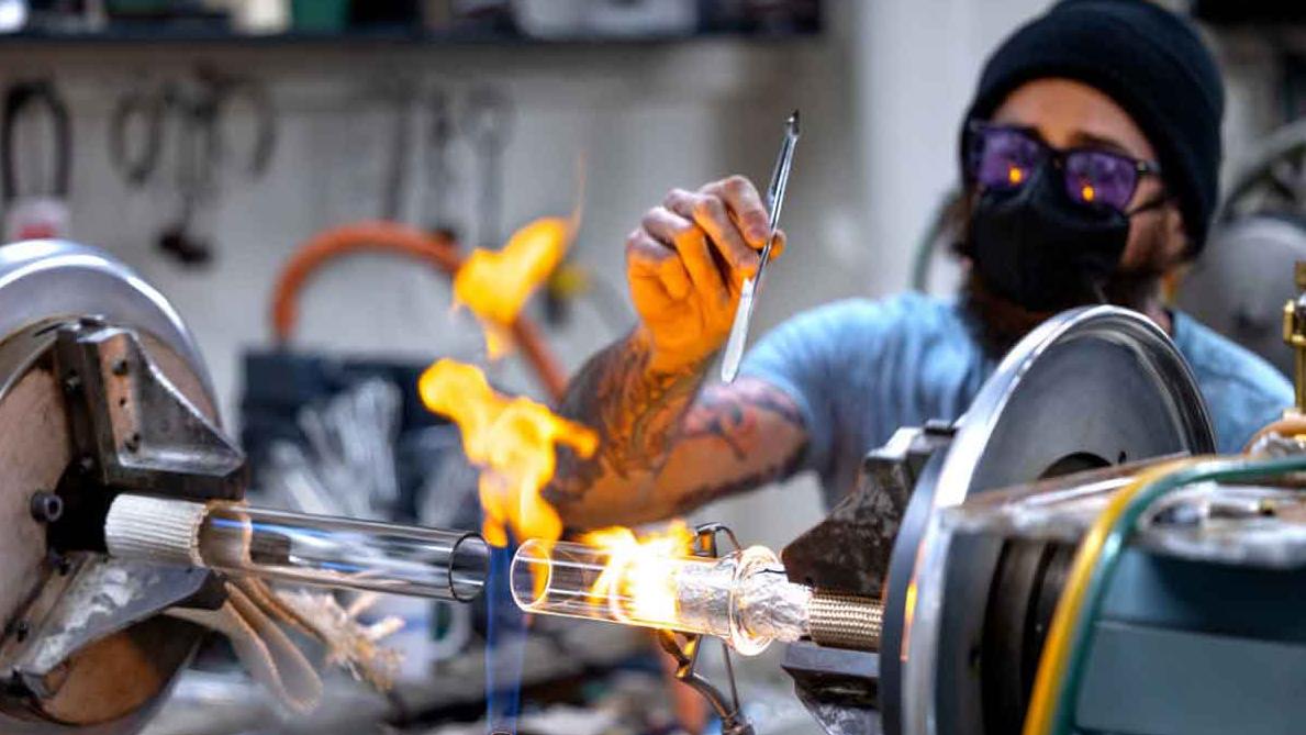 man working with glass and flames