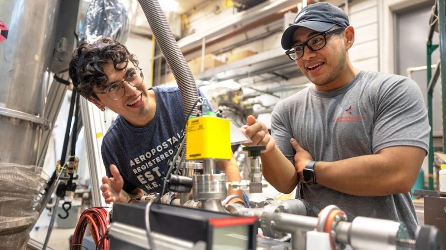 Two people smile, discovering a piece of scientific equipment