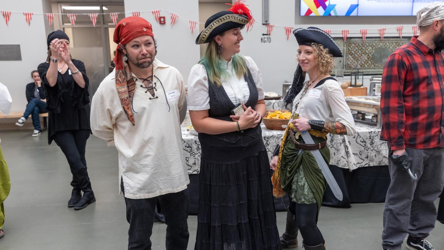 Three people dressed as pirates pose