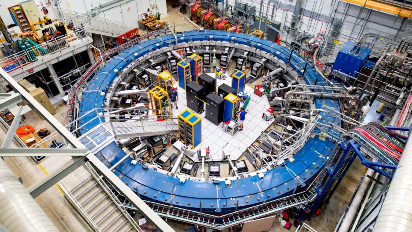 Looking down into a large scientific facility dominated by a blue ring the size of an auditorium