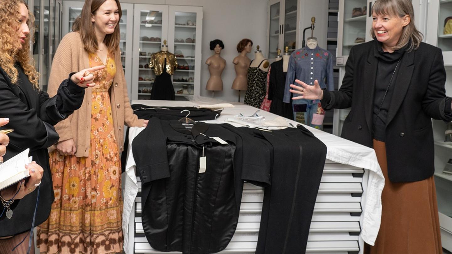 Four people with a few garments between them, on a table