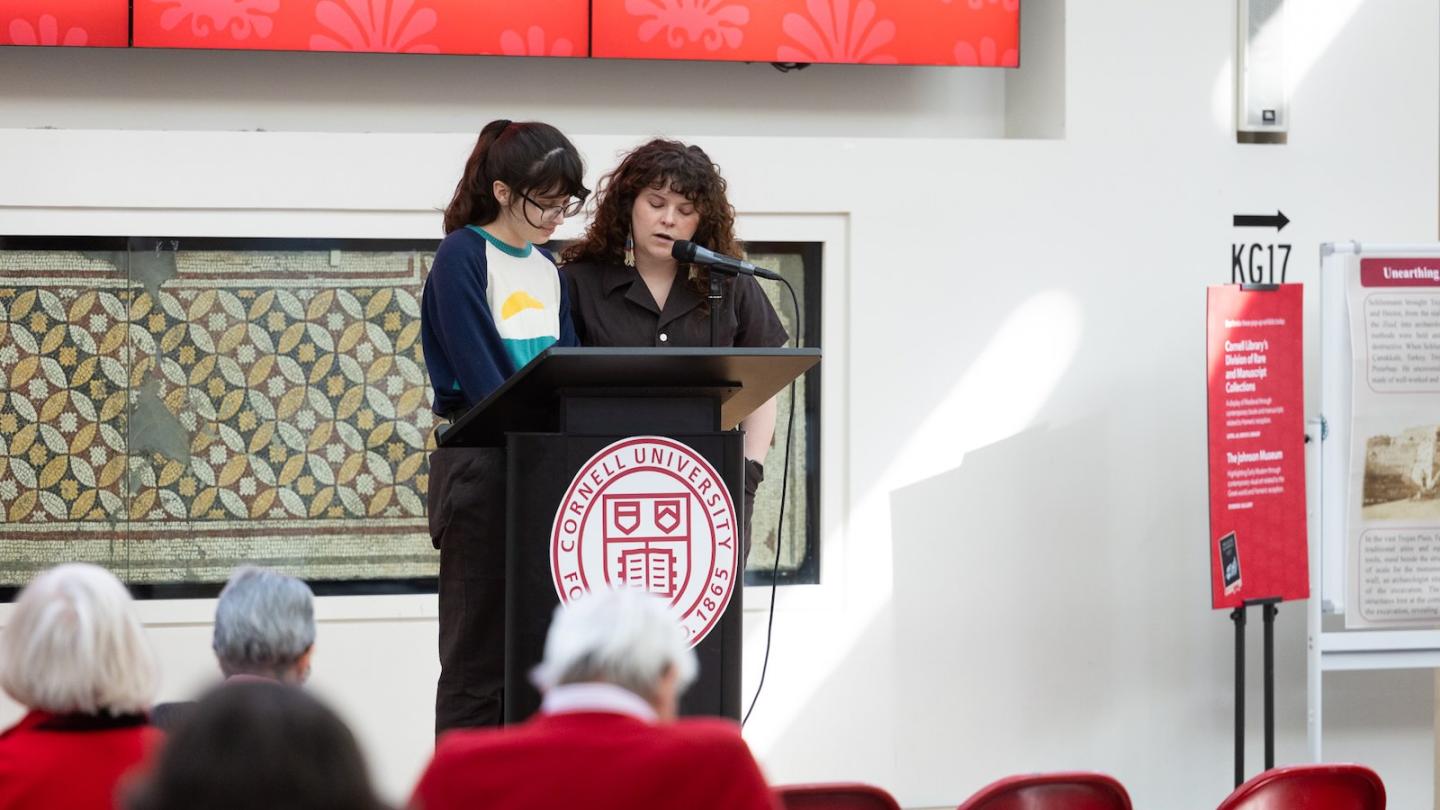 Two people reading at a podium