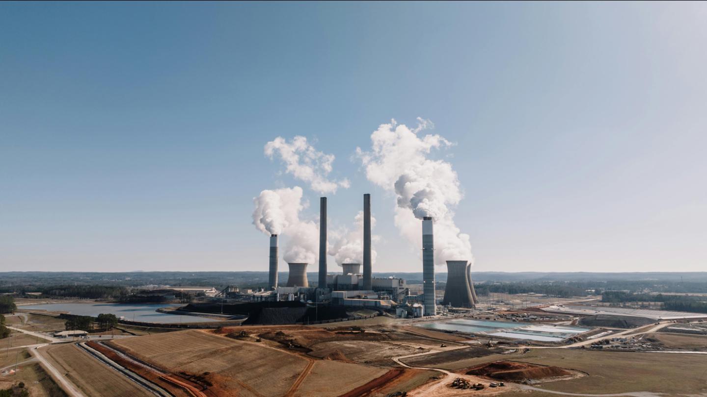 Smoke coming out of a power plant against a clear sky
