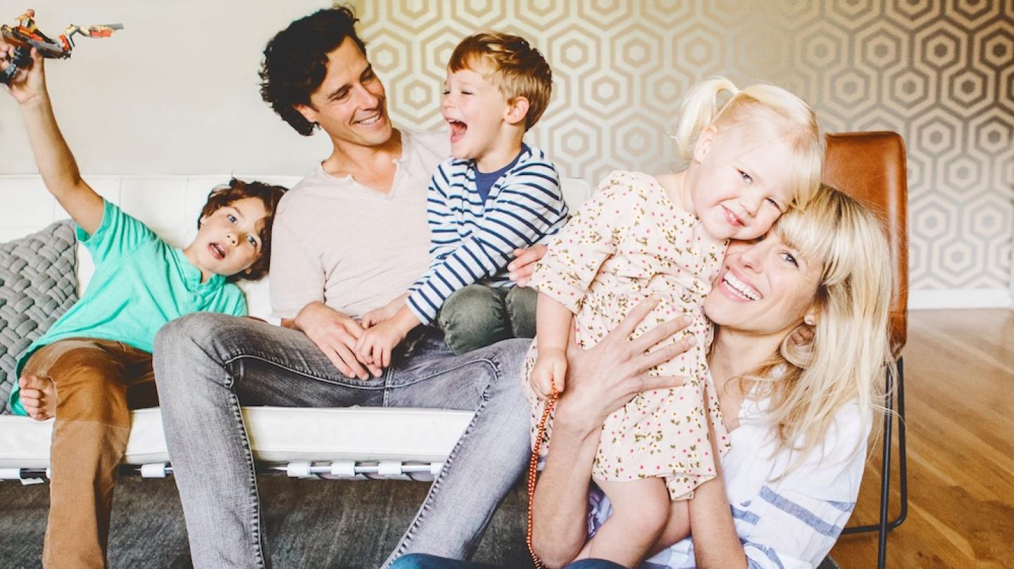 Family of five on and in front of a couch